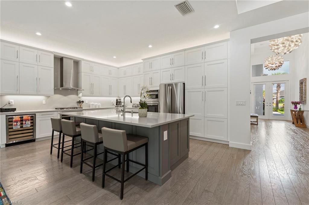 12083 Azalea Way Naples, FL 34120 - Photo 3 of 48 Experience luxury from the moment you step into the grand foyer to the massive great room, kitchen, and dining area, all boasting luxurious hardwood flooring throughout.