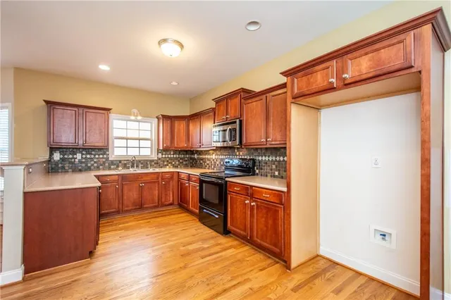 a large kitchen with stainless steel appliances granite countertop a stove a sink and a refrigerator