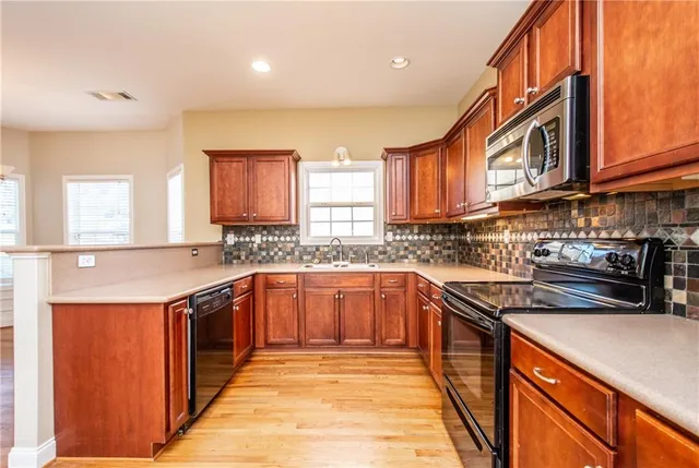 a kitchen with stainless steel appliances granite countertop a stove a sink dishwasher and a refrigerator