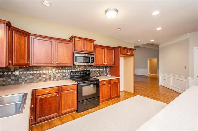 a kitchen with stainless steel appliances granite countertop a sink stove and refrigerator