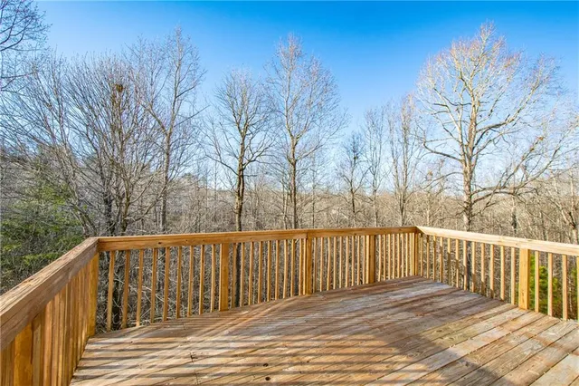 a view of deck and trees with wooden fence