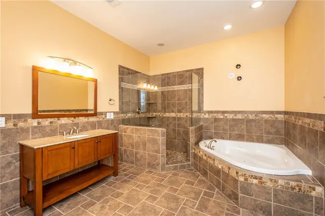a bathroom with a tub a sink and mirror