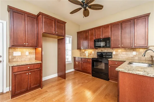 a kitchen with stainless steel appliances kitchen island granite countertop a refrigerator cabinets and wooden floor