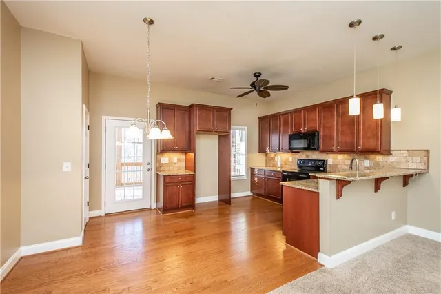 an empty room with windows and ceiling fan