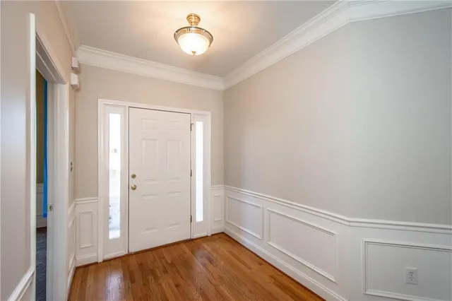 a view of an empty room with closet and wooden floor