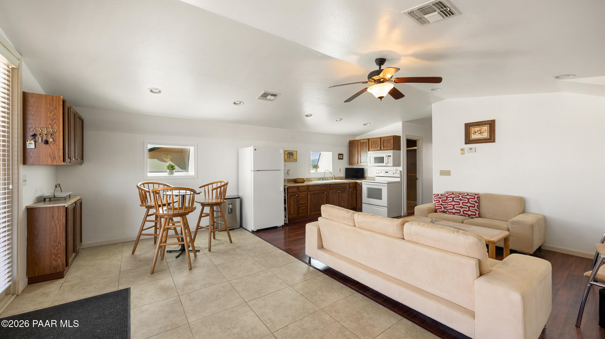 9605 North Coyote Springs Road Prescott Valley, AZ 86315 - Photo 34 of 43 a living room with furniture a flat screen tv and kitchen view