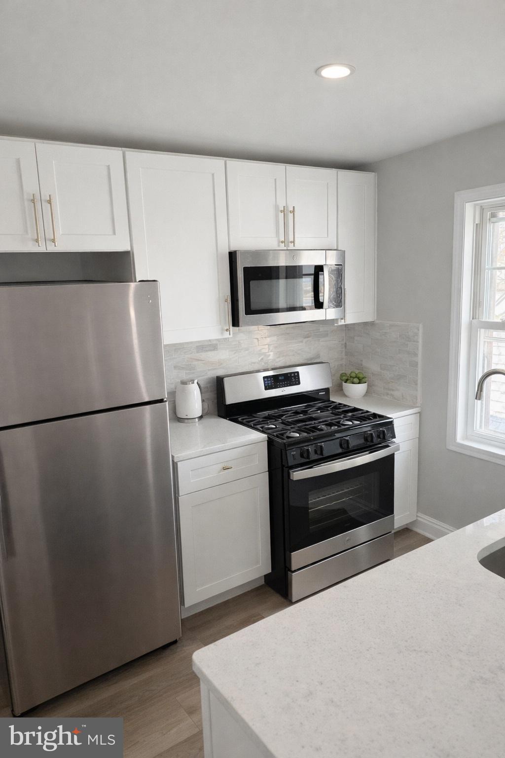 a kitchen with a refrigerator stove and microwave