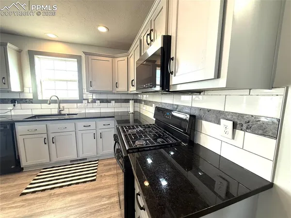 a kitchen with a sink stove and cabinets