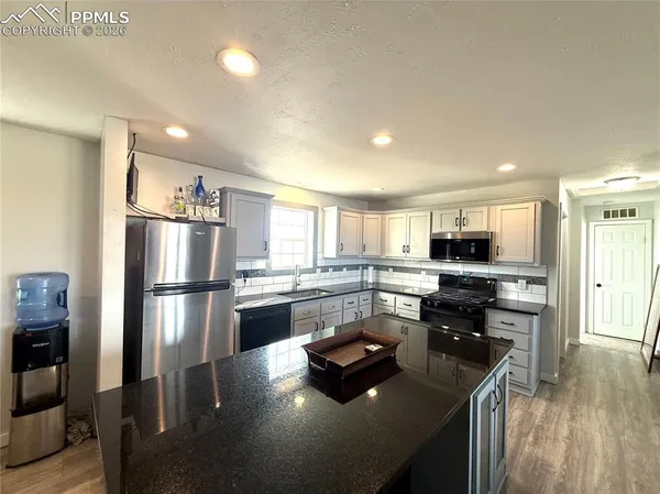 a kitchen with kitchen island white cabinets and refrigerator
