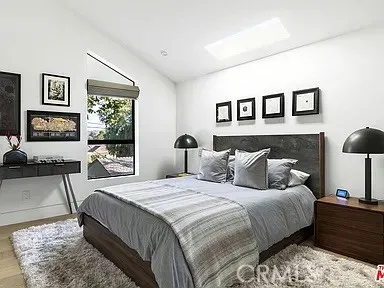 a bedroom with a bed couch and a large window