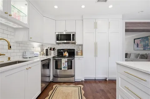 a kitchen with a sink a stove and cabinets