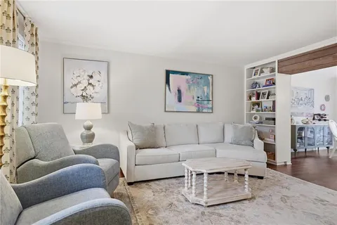 a living room with furniture a rug and a wall painting