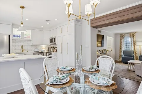 a dining room with furniture a chandelier and wooden floor