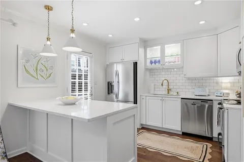 a kitchen with stainless steel appliances a refrigerator sink and white cabinets