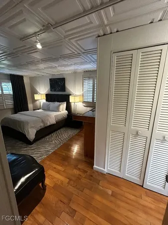 a bedroom with a large bed and a lamp on dresser