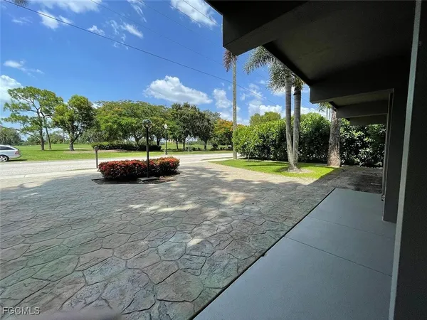 a backyard of a house with fountain table and chairs