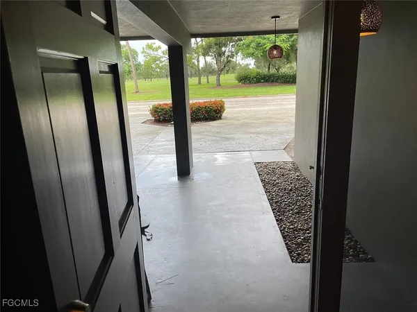 a view of a refrigerator in kitchen and an empty room