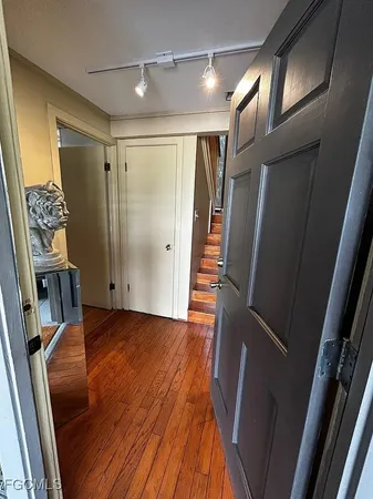 a view of an empty room with a chair and wooden floor
