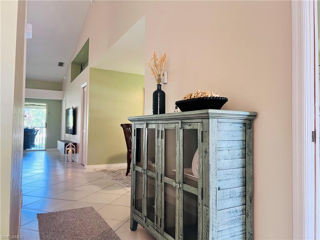 8073 Panther Trail, Unit 1404 Naples, FL 34113 - Photo 8 of 29 a view of a hallway with entryway dining room and chandelier