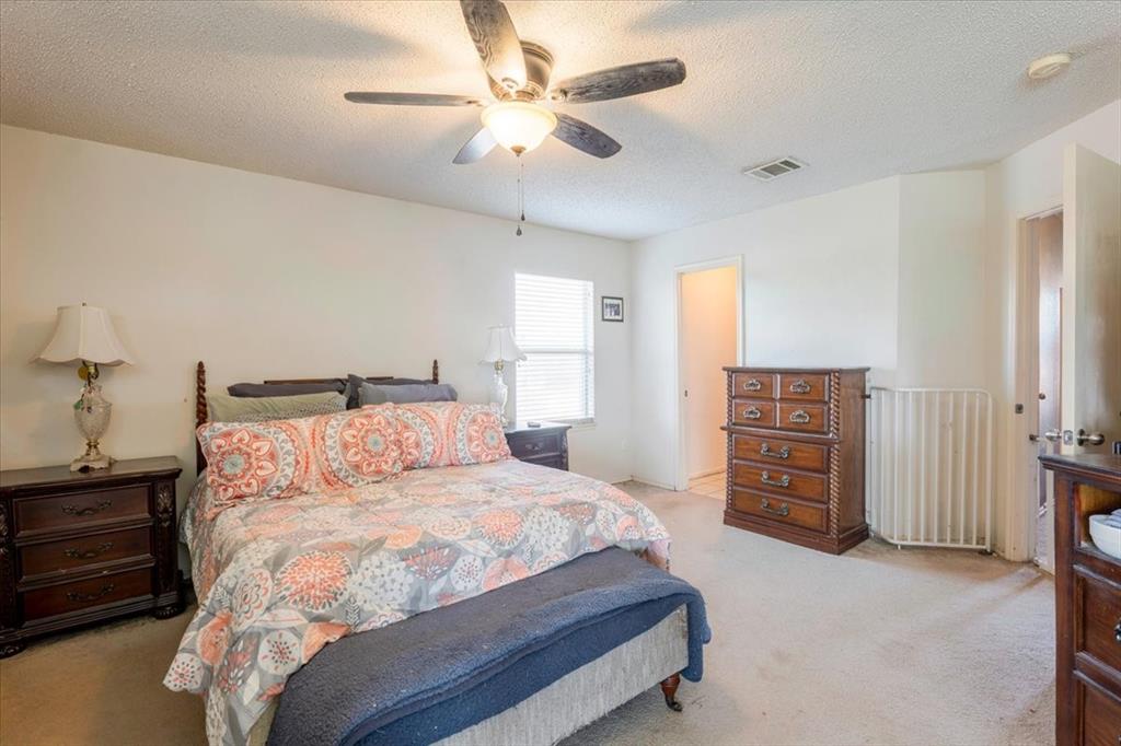 1606 Withers Way Krum, TX 76249 - Photo 16 of 35 a bedroom with a bed and a chandelier