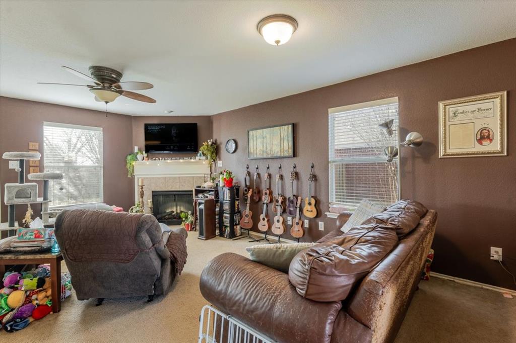 1606 Withers Way Krum, TX 76249 - Photo 29 of 35 a living room with furniture a fireplace and a flat screen tv
