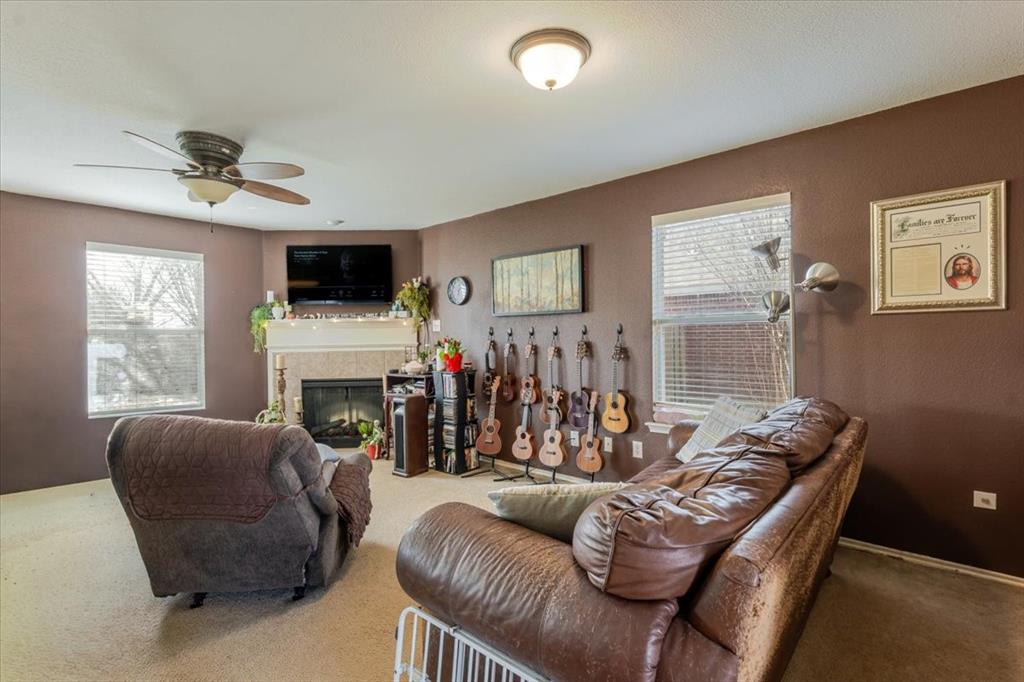 1606 Withers Way Krum, TX 76249 - Photo 3 of 35 a living room with furniture a fireplace and a flat screen tv