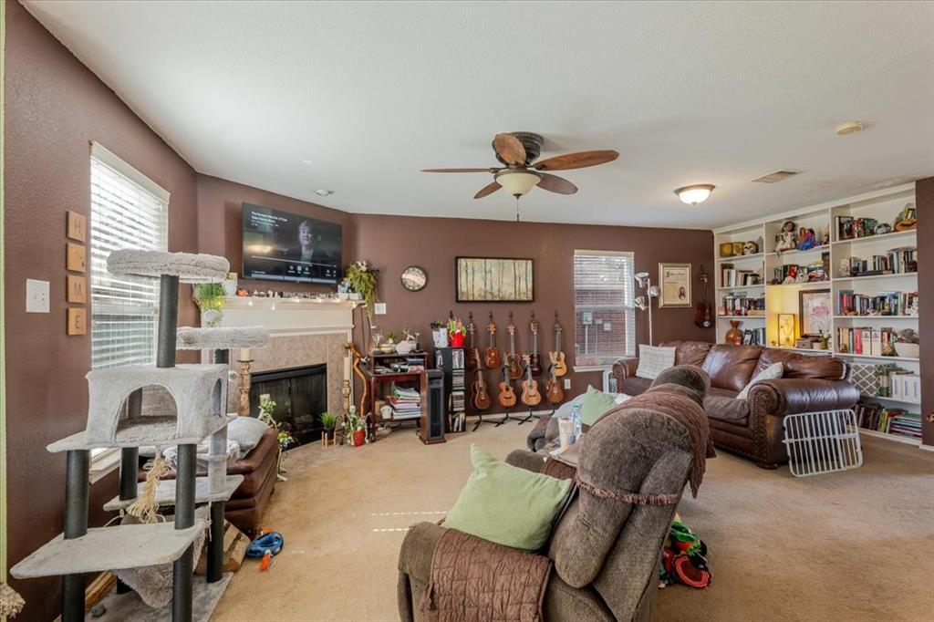 1606 Withers Way Krum, TX 76249 - Photo 32 of 35 a living room with furniture a fireplace and a flat screen tv