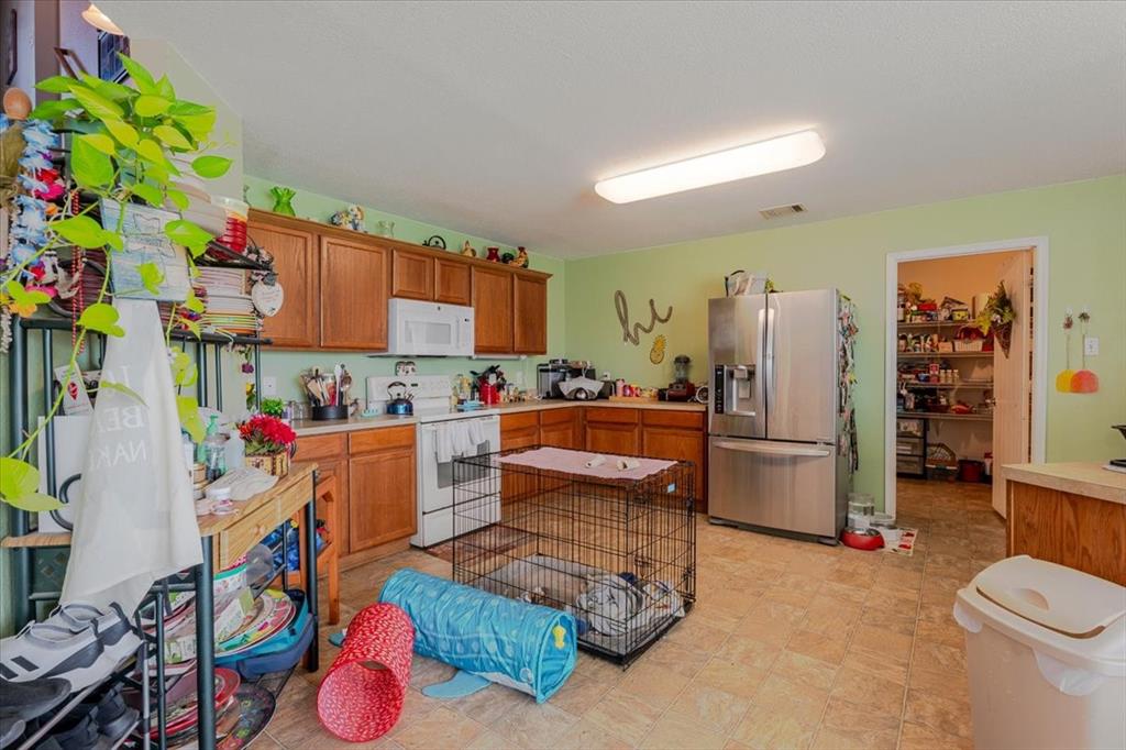 1606 Withers Way Krum, TX 76249 - Photo 34 of 35 a kitchen that has a lot of white cabinets and stainless steel appliances