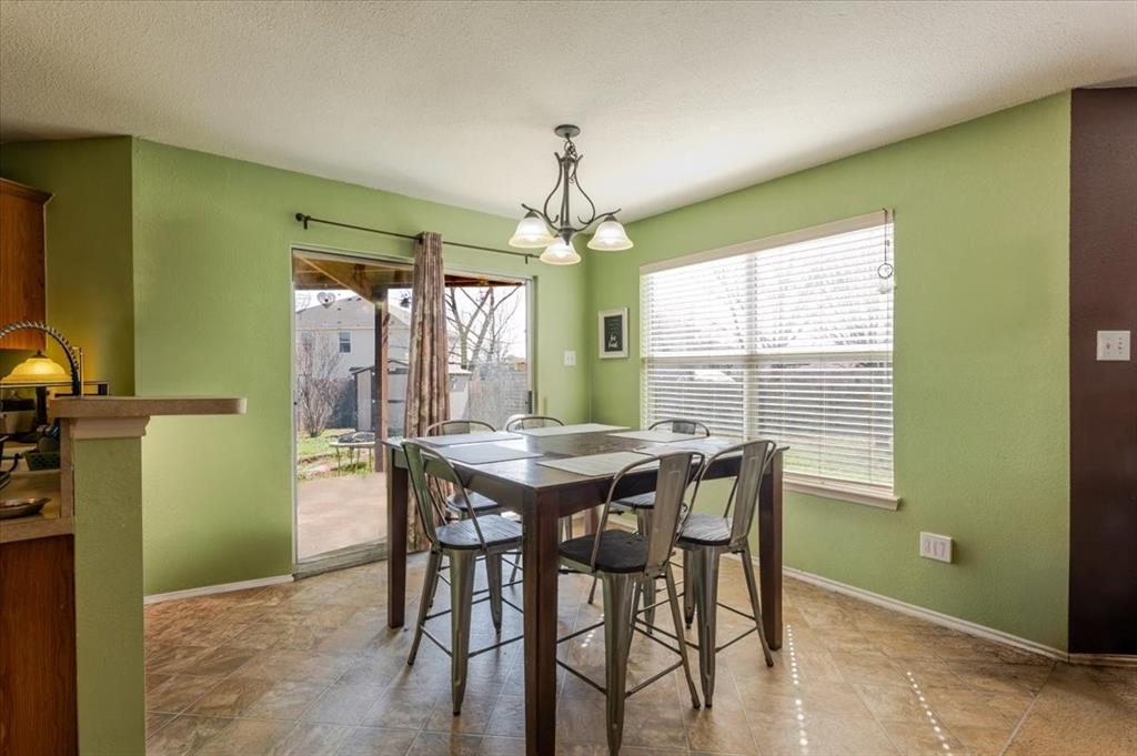 1606 Withers Way Krum, TX 76249 - Photo 7 of 35 a dining room with furniture a chandelier and window