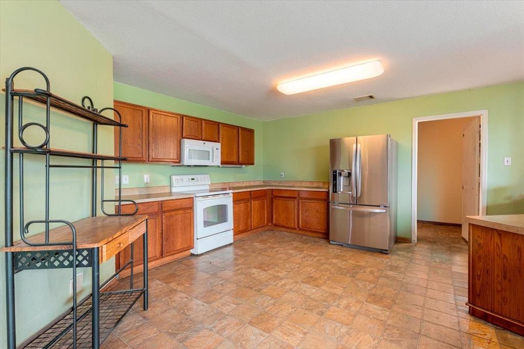 1606 Withers Way Krum, TX 76249 - Photo 9 of 35 a kitchen with stainless steel appliances granite countertop a refrigerator and a stove top oven