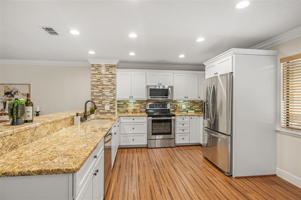 533 Sandy Hook Road Treasure Island, FL 33706 - Photo 15 of 46 a kitchen with a refrigerator a sink dishwasher with a stove and wooden floor