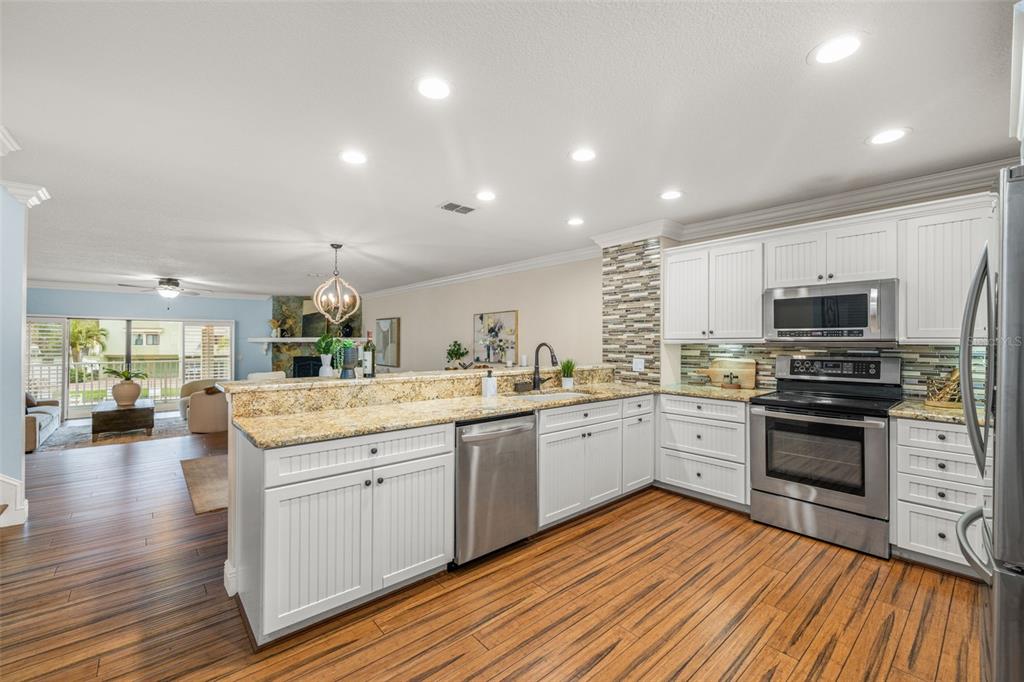533 Sandy Hook Road Treasure Island, FL 33706 - Photo 16 of 46 a large kitchen with stainless steel appliances granite countertop a stove and a sink