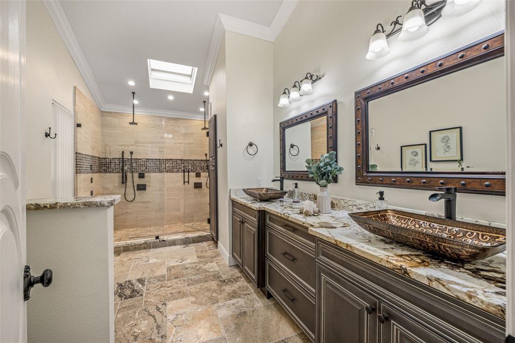 533 Sandy Hook Road Treasure Island, FL 33706 - Photo 22 of 46 a bathroom with a granite countertop sink a mirror and a shower