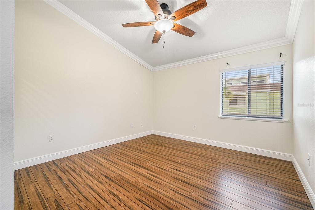 533 Sandy Hook Road Treasure Island, FL 33706 - Photo 27 of 46 a view of a room with wooden floor and a ceiling fan