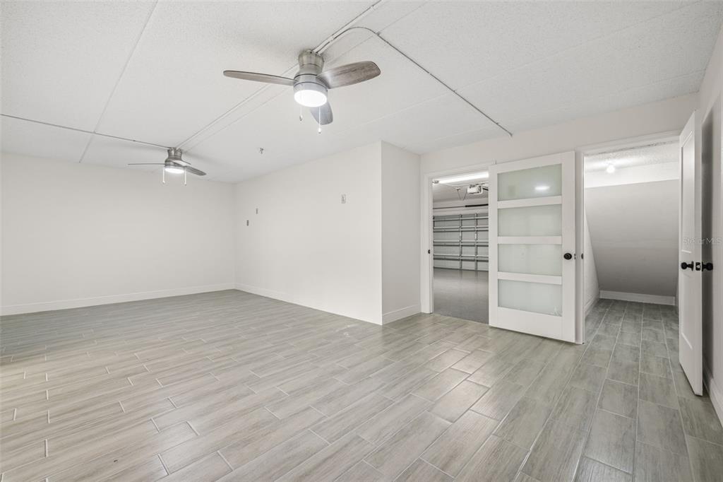533 Sandy Hook Road Treasure Island, FL 33706 - Photo 29 of 46 an empty room with wooden floor a ceiling fan white walls and windows