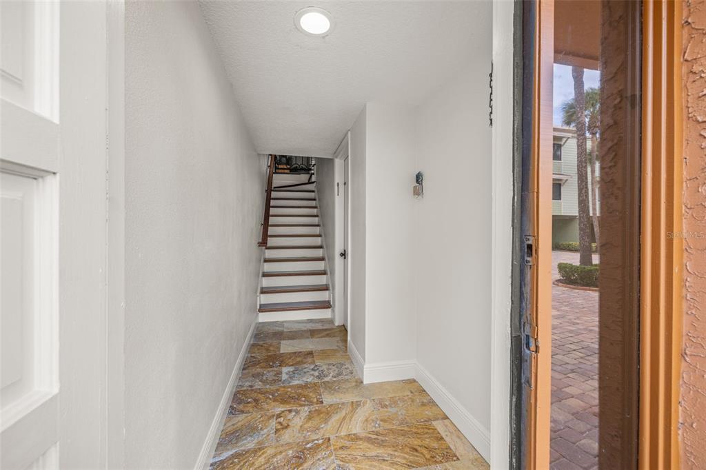 533 Sandy Hook Road Treasure Island, FL 33706 - Photo 5 of 46 a view of a hallway with wooden floor and staircase