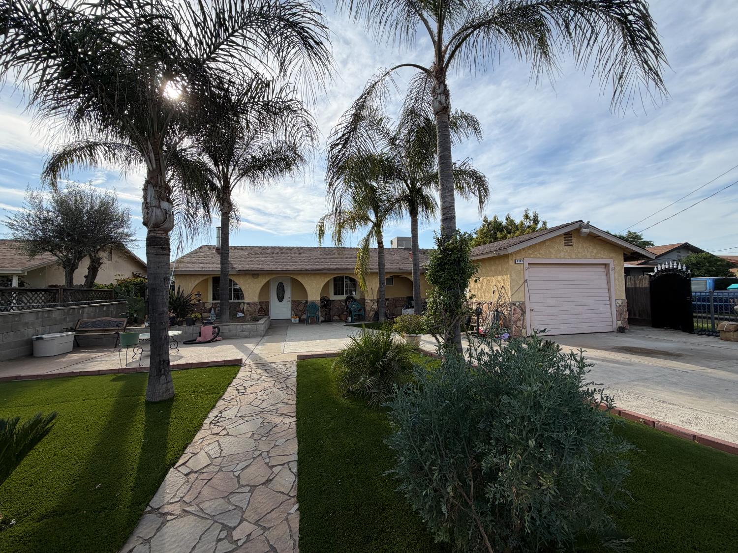 a front view of a house with garden and trees