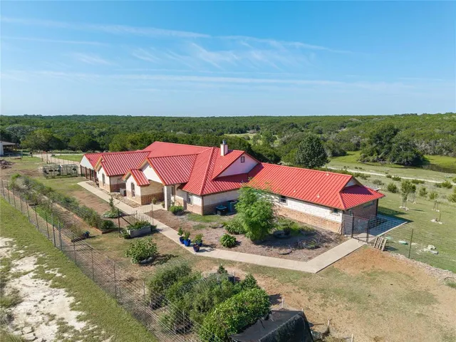 an aerial view of a house with a garden and lake view