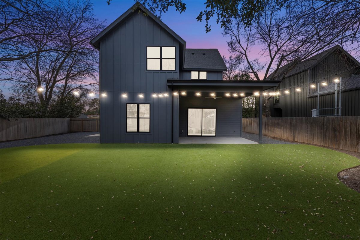 4527 Clawson Road Austin, TX 78745 - Photo 1 of 1 Back of property at dusk with board and batten siding, a patio area, and a fenced backyard
