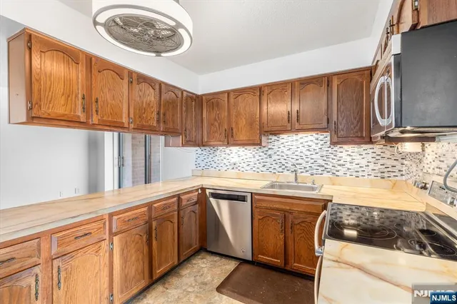 a kitchen with stainless steel appliances granite countertop a sink and cabinets