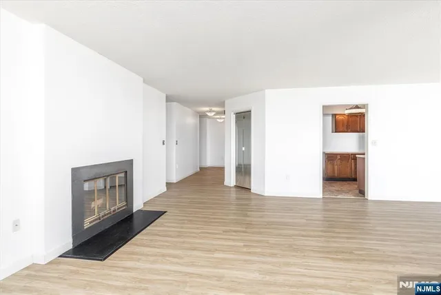 a view of an empty room with wooden floor