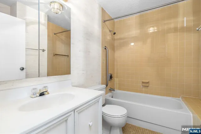 a bathroom with a sink mirror toilet and bathtub