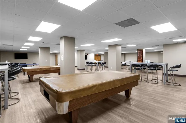 a living room with dining table tennis pool table and chairs
