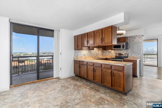 a kitchen with stainless steel appliances granite countertop a stove a sink and a refrigerator