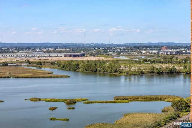 an aerial view of ocean and residential houses with outdoor space