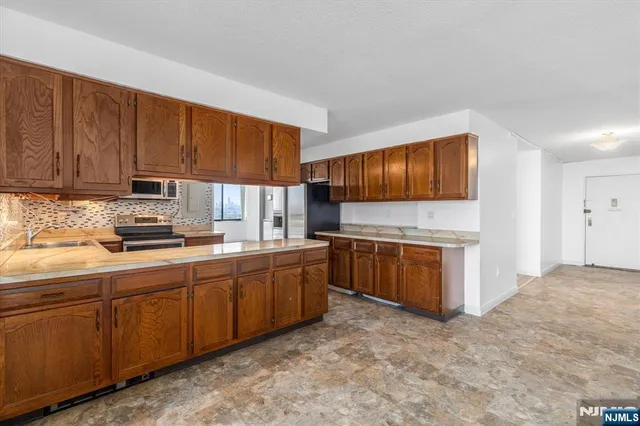 a kitchen with stainless steel appliances granite countertop a stove sink and cabinets