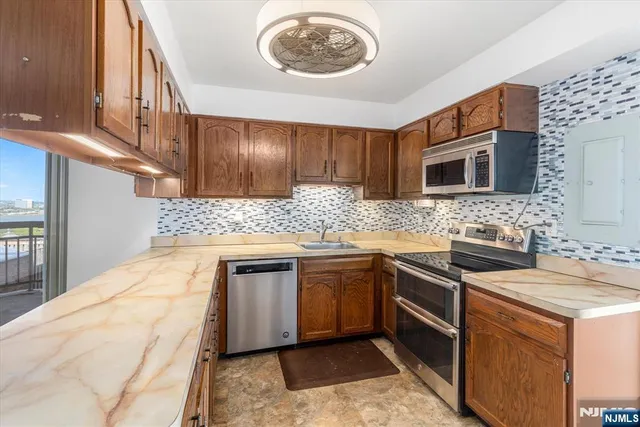 a kitchen with stainless steel appliances granite countertop a sink stove and microwave