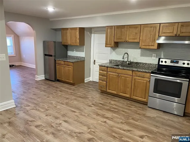 a kitchen with granite countertop a stove and a sink