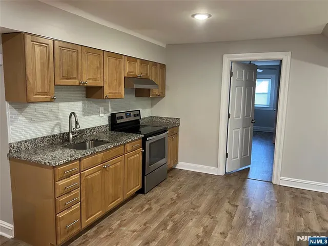 a kitchen with stainless steel appliances granite countertop a stove a sink and a microwave