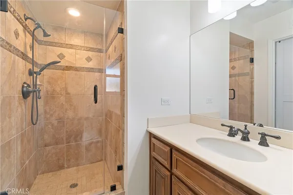 a bathroom with a shower sink vanity and mirror